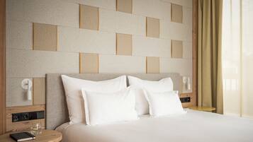 A neatly made bed with white linens, a bedside table with a book and glasses, and a wall with a geometric pattern.