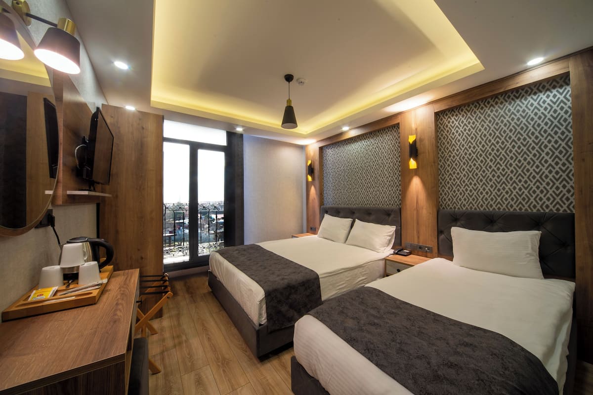 Standard Triple Room | Minibar, in-room safe, desk, blackout drapes