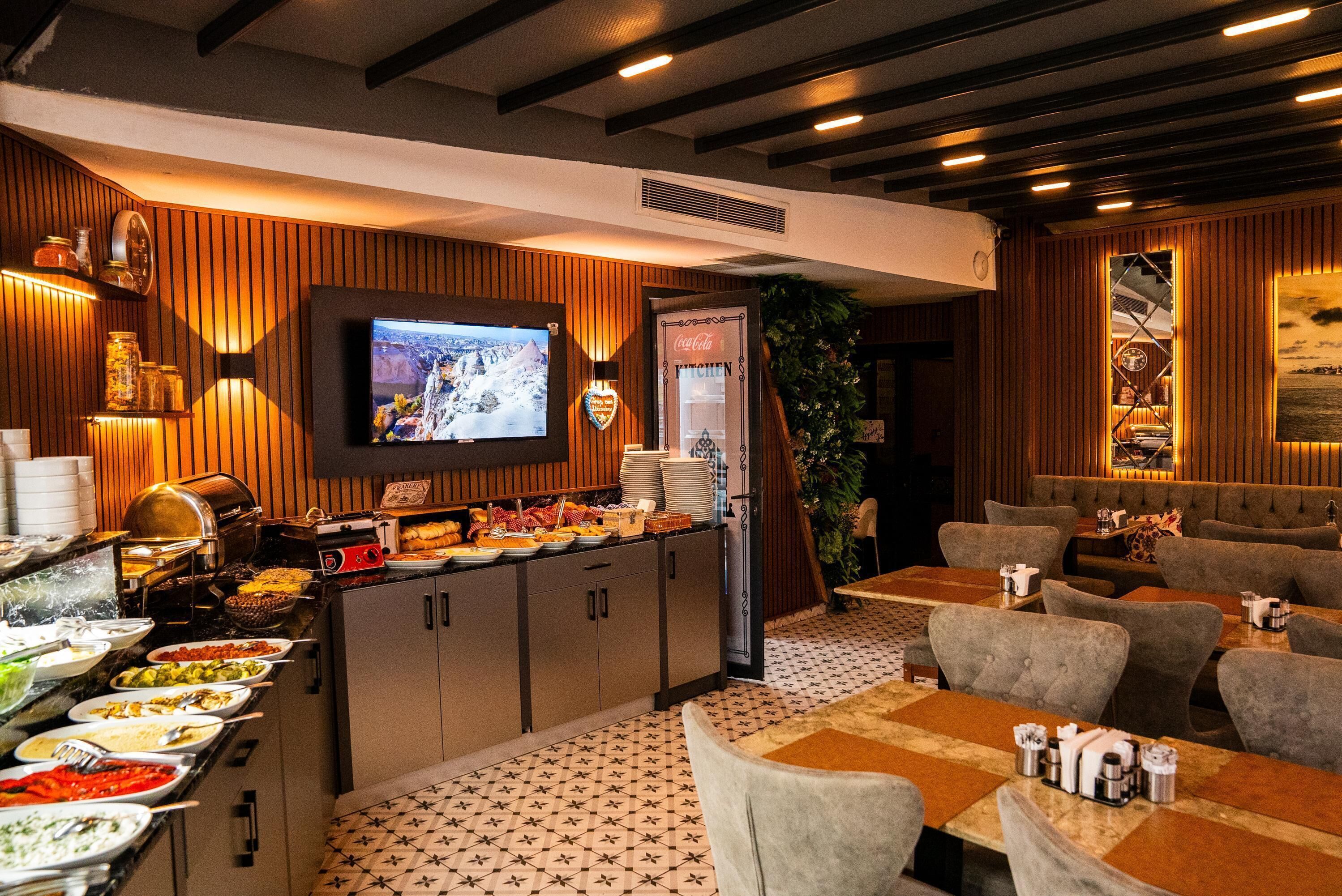 Un espace buffet proposant une variété de plats, un téléviseur fixé au mur et des espaces aménagés pour s'asseoir.