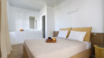 Un dormitorio ordenado con cama, mesita de noche y una pequeña mesa con una bandeja de desayuno.