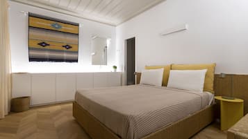 Un dormitorio con una cama grande, una mesita de noche, un espejo y una ventana con vistas al exterior.
