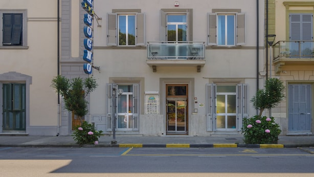 A multi-story hotel with a central entrance, balconies, and a sign indicating it is a hotel. - Hotel Sogno (Viareggio)