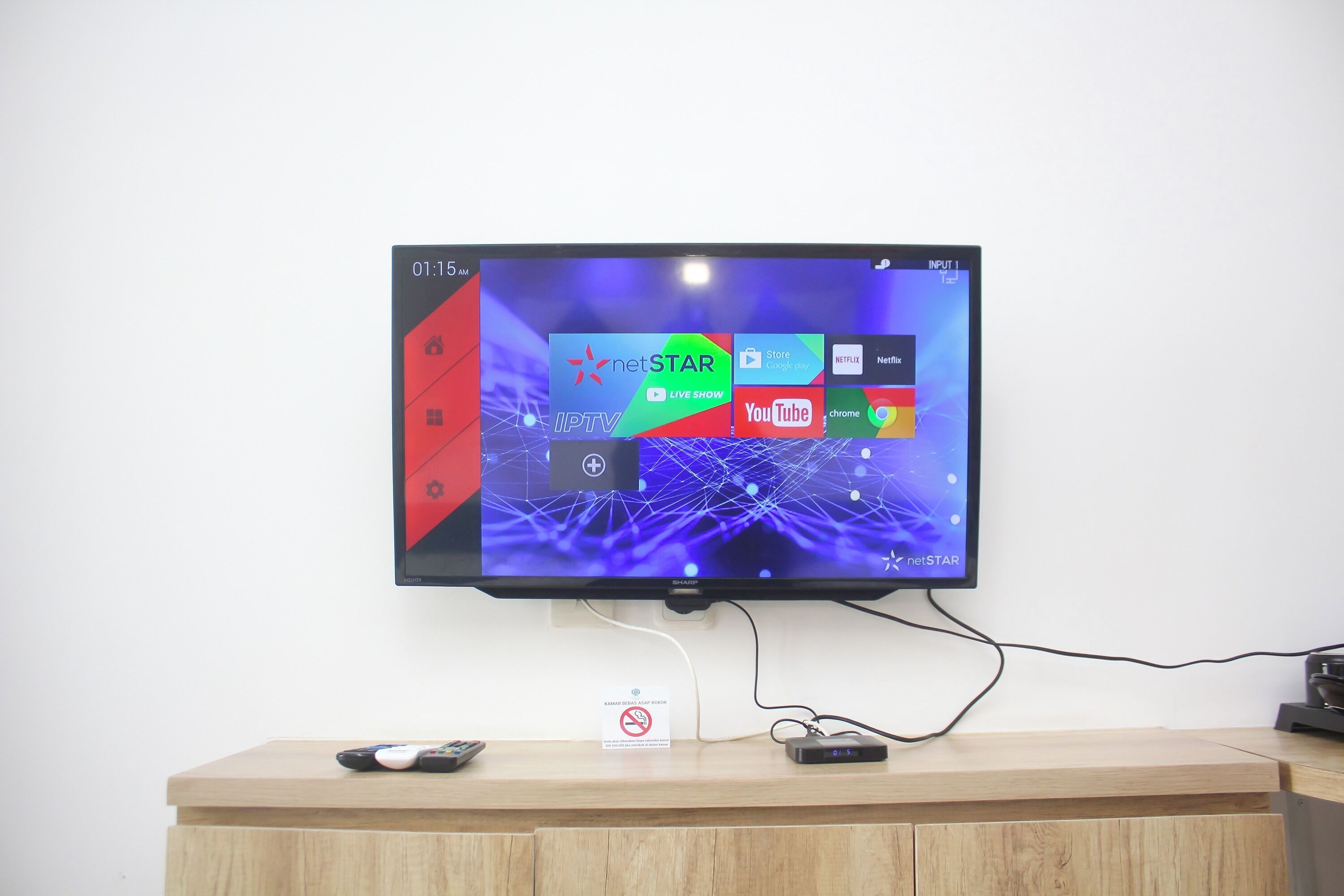 Televisor de pantalla plana montado en una pared, mostrando varias aplicaciones de transmisión.