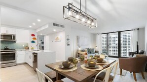A modern apartment with a kitchen, dining area, and living room. - Stunning Southern Beach Views the Whole Family will Love; Heated Pool & WiFi ~Walk to Dining & Shops (Marco Island)