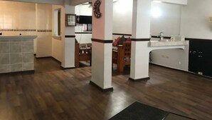 A spacious kitchen with wooden flooring, a dining area with a wooden table and chairs, and a modern kitchen counter.
