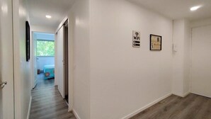 Ein Flur mit einem Schild, das freies WLAN anzeigt, einer Tür und einem Blick in einen Raum mit einem Bett.