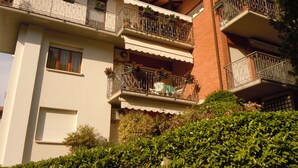 Un edificio residenziale a più piani con balconi, alcuni dei quali adornati con piante e fiori.