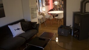 Ein Wohnzimmer mit einer Couch, einem Couchtisch, einem Kamin und einem Essbereich mit Tisch und Stühlen.