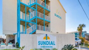 A building with a sign reading "SUNDIAL CONDOMINIUMS" and a blue and beige exterior. - Beautiful 3 Bedroom BEACHFRONT Condo - Sundial #F3 - Sleeps 10 (Gulf Shores)