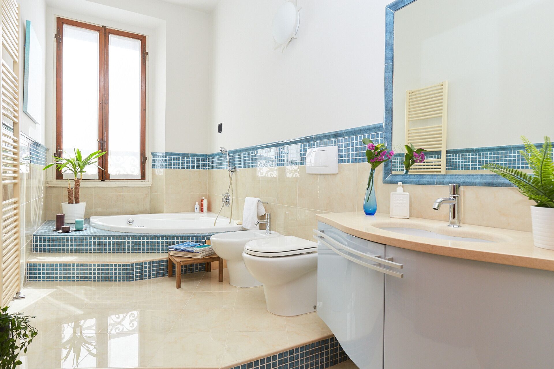 A bathroom with a bathtub, toilet, sink, and a mirror.