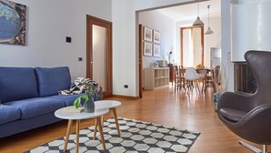 Ein modernes Wohnzimmer mit einem blauen Sofa, einem Couchtisch und einem gemusterten Teppich.