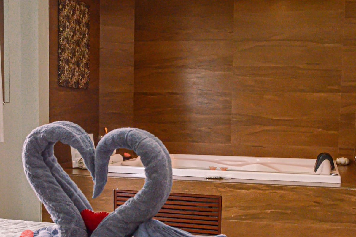 A bed with a swan-shaped towel arrangement.