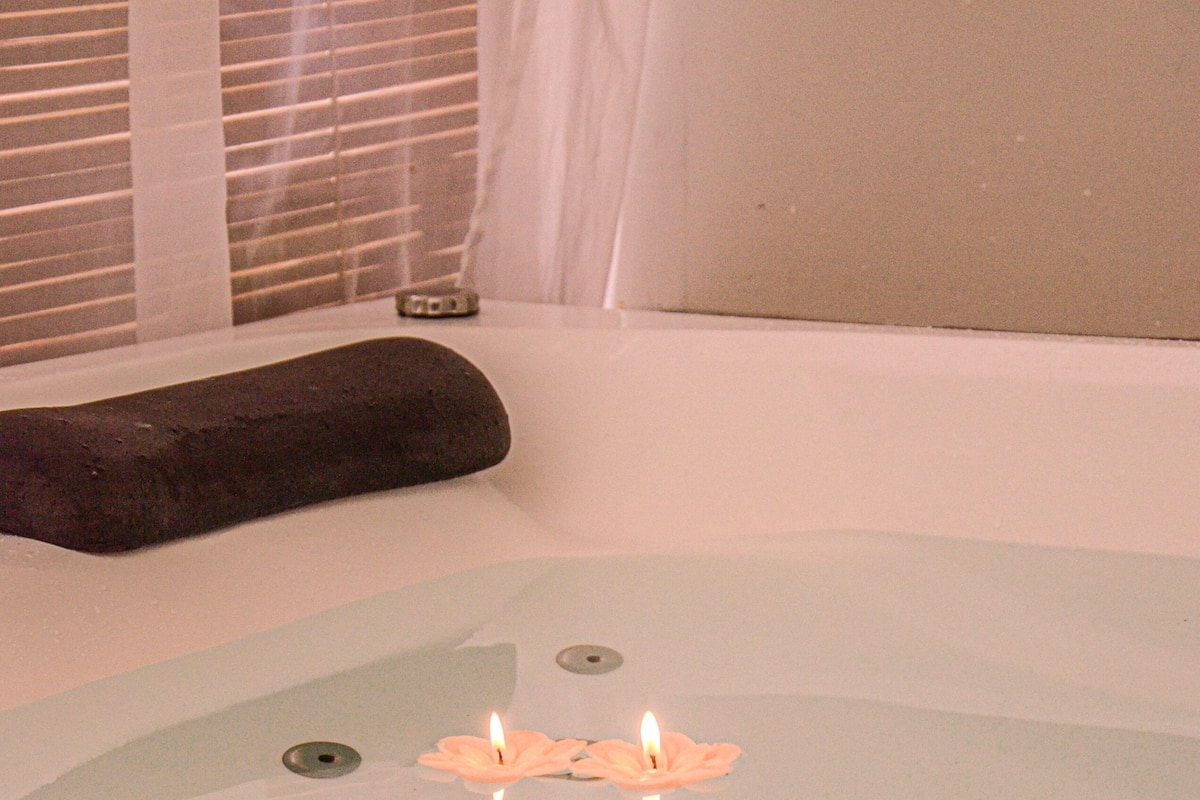 A bathtub with a candle and a stone.