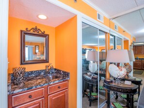 Bathroom features a sink, shower, and vanity with a mirror.