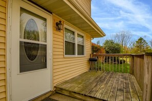 A residential property with a front porch, a door with a glass panel, and a small outdoor seating area.