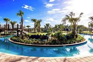 A pool surrounded by palm trees and a clear blue sky.