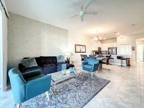 A modern living room with a sofa, two armchairs, a coffee table, and a patterned rug.