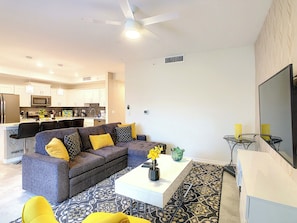 A modern living room with a sofa, coffee table, and a TV.
