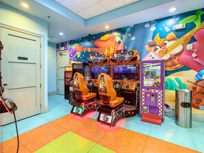Een kamer met spelautomaten, een deur met de tekst 'Alleen voor medewerkers' en een muurschildering.