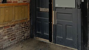 Una puerta negra con el número 107 y un cartel que dice 'The Lofts @ 107 Short Term Rentals'.
