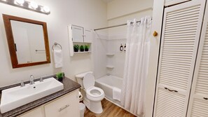 Deluxe appartement | Badkamer | Een bad/douchecombinatie, handdoeken, zeep, toiletpapier