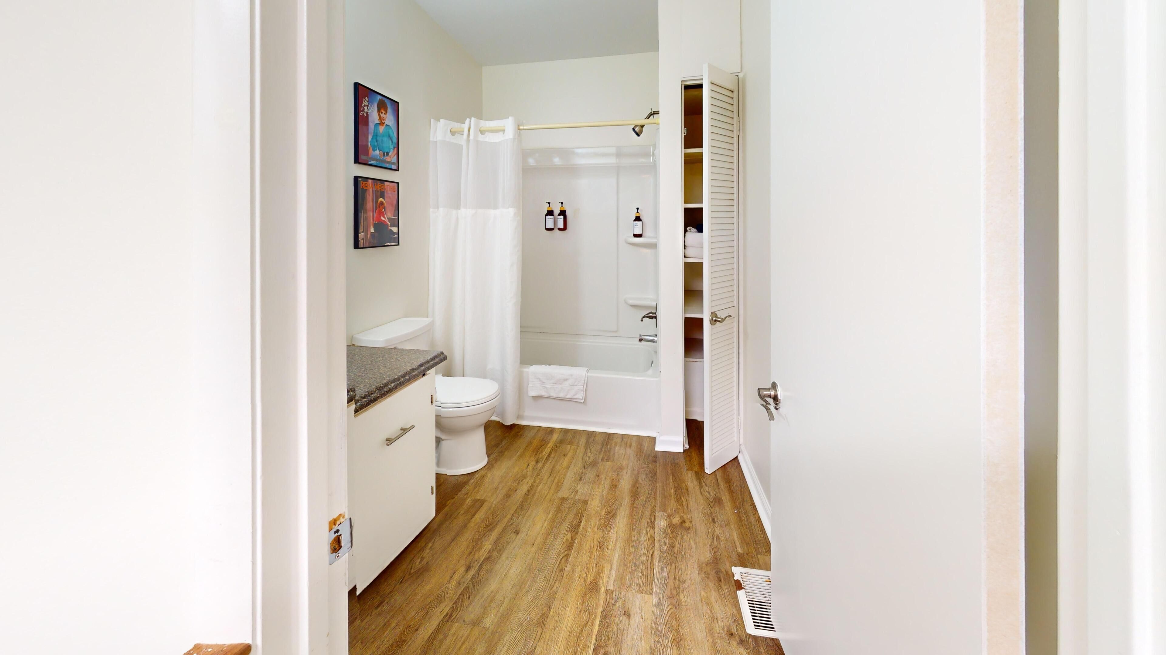 Une salle de bain comprenant des toilettes, un lavabo, une douche et un porte-serviettes.