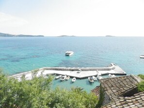 Un port de plaisance situé sur la côte, avec des bateaux amarrés, une jetée et une vue sur la mer.