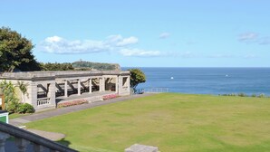 A coastal view with a stone structure, a grassy lawn, and the sea in the background. - 2 bedroom accommodation in Scarborough (Scarborough)