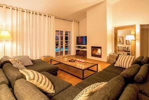 A living room with a sofa set, a coffee table, a fireplace, and a TV.