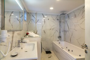 Een bad/douchecombinatie, een haardroger, handdoeken, zeep