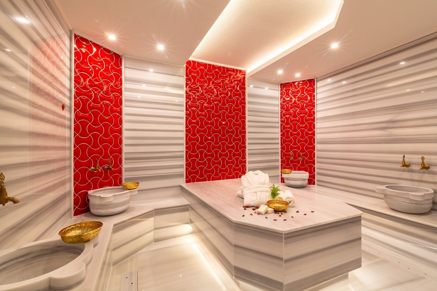 Un baño moderno con tocador de mármol, dos lavamanos y un espejo grande.