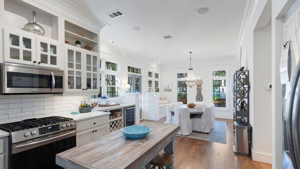 A modern kitchen with white cabinetry, stainless steel appliances, and a rustic wooden island. - 2 Min Walk to the Beach, Pool + Town Square! Rosemary Family Home (Panama City Beach)