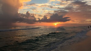 A sunset over the ocean with waves and a beach in the foreground. - 2 Min Walk to the Beach, Pool + Town Square! Rosemary Family Home (Panama City Beach)