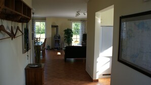 A spacious living area with a fireplace, dining table, and chairs.