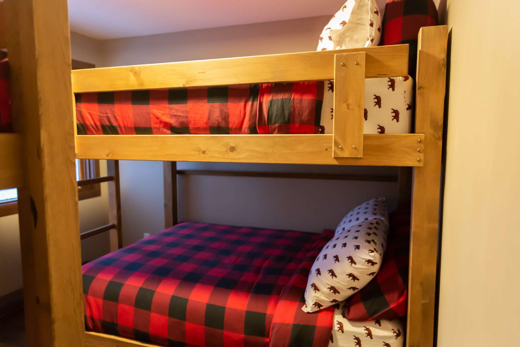 A bunk bed with a checkered bedspread and matching pillow.