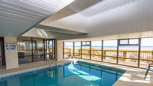An indoor swimming pool with a view of the beach, a sign indicating shallow water, and a lifeguard chair. - 3 Bedroom/2 Bath Oceanfront Timeshare in Myrtle Beach (Murrells Inlet)