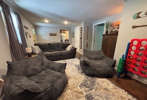 A living room with two dark sofas, a patterned rug, and a wooden cabinet. - 5 BR lake house with dock  (Jacksboro)