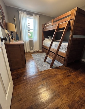 A bunk bed room with a wooden ladder, a desk with a lamp, and a window with curtains. - 5 BR lake house with dock  (Jacksboro)