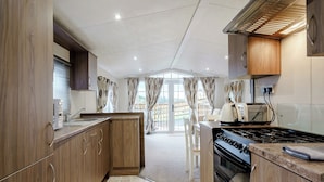 A modern kitchen with wooden cabinets, a gas stove, and a built-in oven.