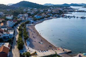 Experience a serene coastal retreat with a picturesque beach, marina, and traditional Mediterranean architecture.