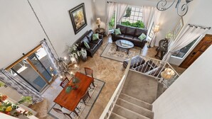 A spacious living area with a dining table, sofa, and staircase. - 😎🏜️ <br>NEW Beautiful Relaxed Elegant Retreat.2330 sf 4b3b.  (Glendale)
