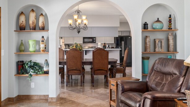 A spacious living area with a brown leather sofa, a dining table with chairs, and a kitchen in the background. - 😎🏜️ <br>NEW Beautiful Relaxed Elegant Retreat.2330 sf 4b3b.  (Glendale)