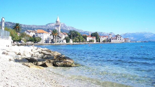 A coastal town with historic buildings, a prominent church tower, and clear blue waters. - Modern Apartment in Kastel Stari (Kastela)