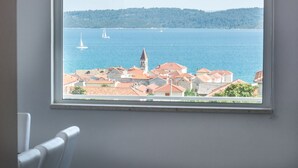 A window view of a coastal town with buildings and sailboats on the water. - Apartment in Seget Donji Near Trogir Old Town (Seget)