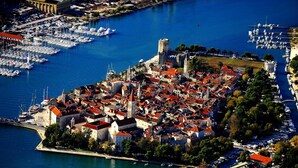 An aerial view of a coastal town with historic buildings, a marina, and a prominent castle. - Apartment in Seget Donji Near Trogir Old Town (Seget)