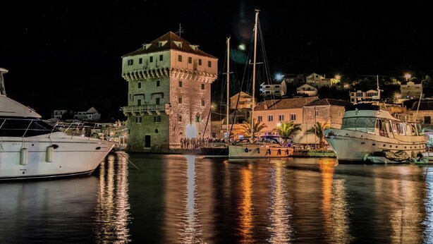 A historic tower and a marina with boats at night. - Holiday Home With Outdoor Hot Tub, Near the Sea (Marina)