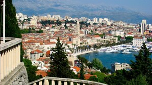 A coastal cityscape with a prominent church tower, a marina with boats, and a stone balustrade. - Apartment in Okrug Gornji Near the Beach (Okrug)