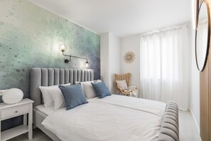 A modern bedroom with a large bed, a nightstand, a wall-mounted lamp, a chair, and a window with curtains. - Apartment 5 km From Trogir's Center (Split)