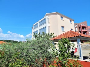A multi-story building with a flat roof and a balcony.