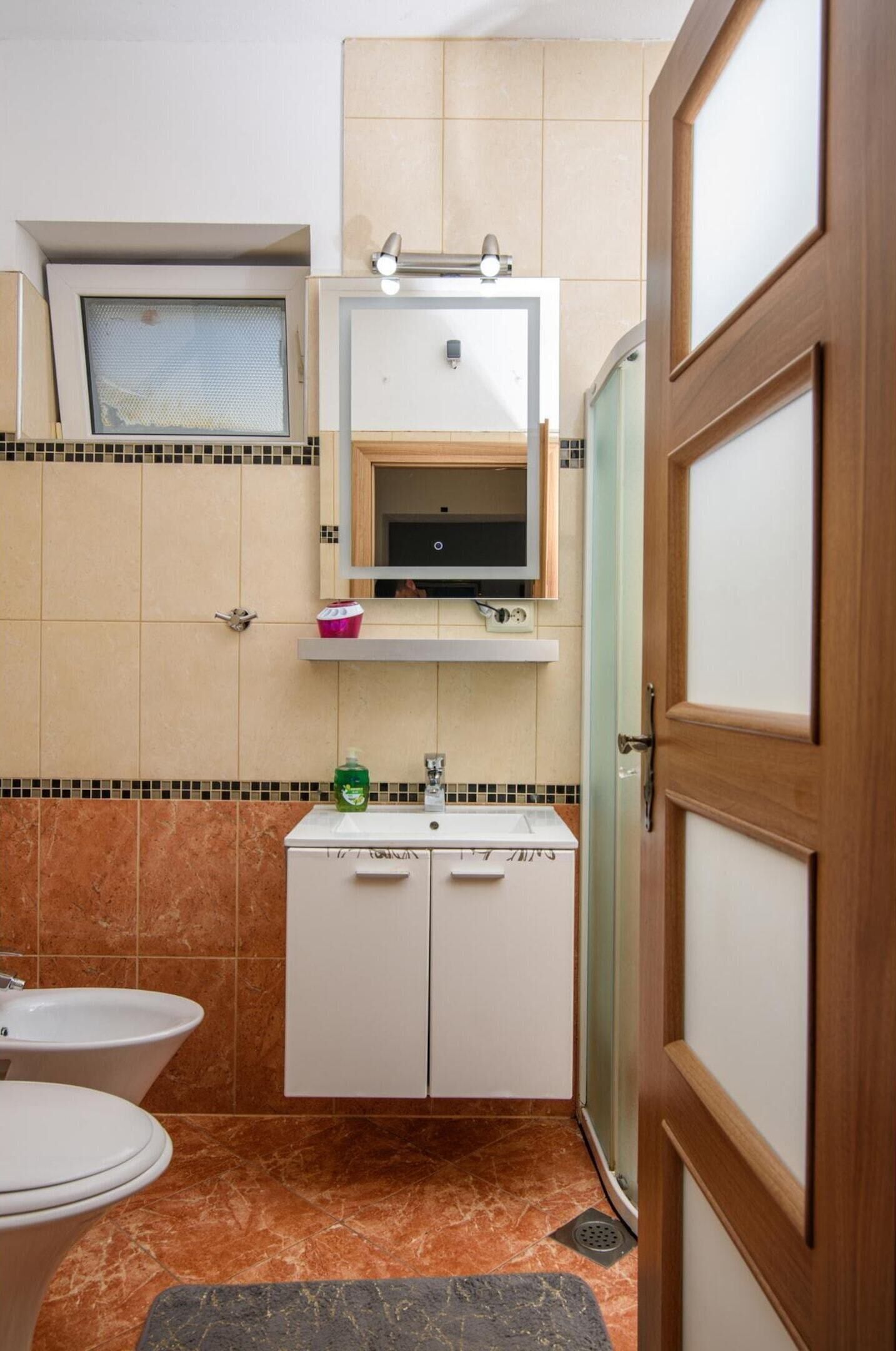 A compact bathroom with a toilet, sink, and cabinet.